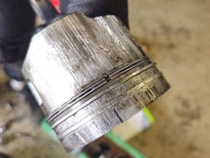 Korkean öljynkulutuksen korjaus Keravalla – esimerkki kuluneesta männästä, joka aiheuttaa öljyn palamista.